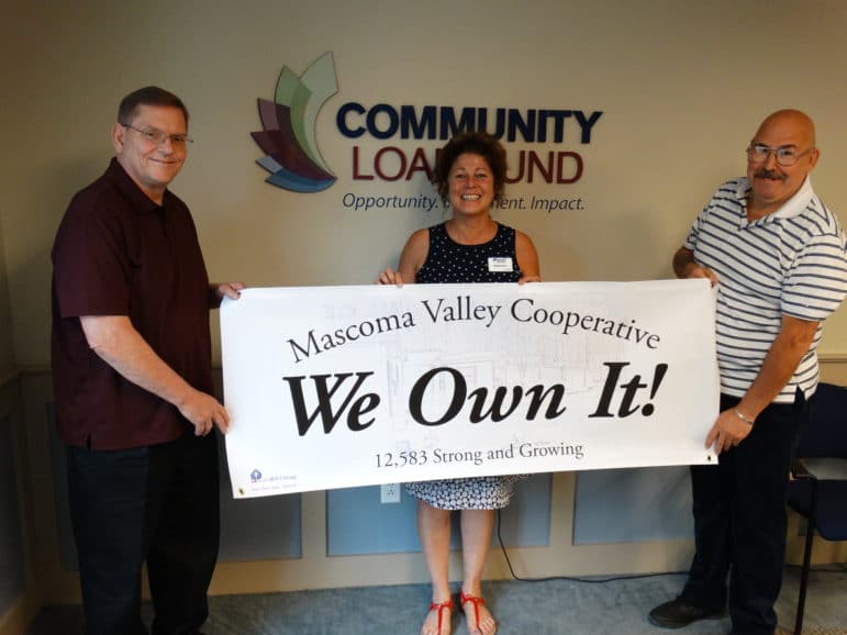 Photo of Darrel Brock, Mascoma Valley Treasurer; Michelle Supry of ROC-NH; and Lenny Beliveau, Mascoma Valley President, holding a We Own It! banner at the Community Loan Fund in Concord.