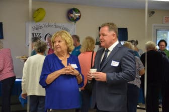 Photo of Gail McManus, a Board Member at Halifax Estates, talking with Massachusetts State Rep. Tom Calter during the celebration of the residents' purchase.